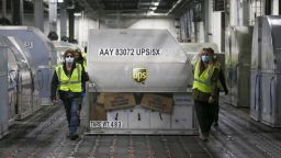 UPS employees move one of two shipping containers containing the first shipments of the Pfizer and BioNTech COVID-19 vaccine inside a sorting facility at UPS Worldport on December 13, 2020 in Louisville, Kentucky. (Photo by Michael Clevenger - Pool/Getty Images)