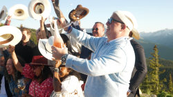Chef Andrew Zimmern sabers a bottle at the 2025 Food& Wine Classic in Aspen, Colorado